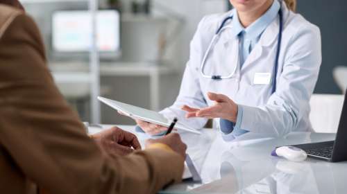 Close,Up,Of,Female,Doctor,Holding,Tablet,And,Gesturing,To